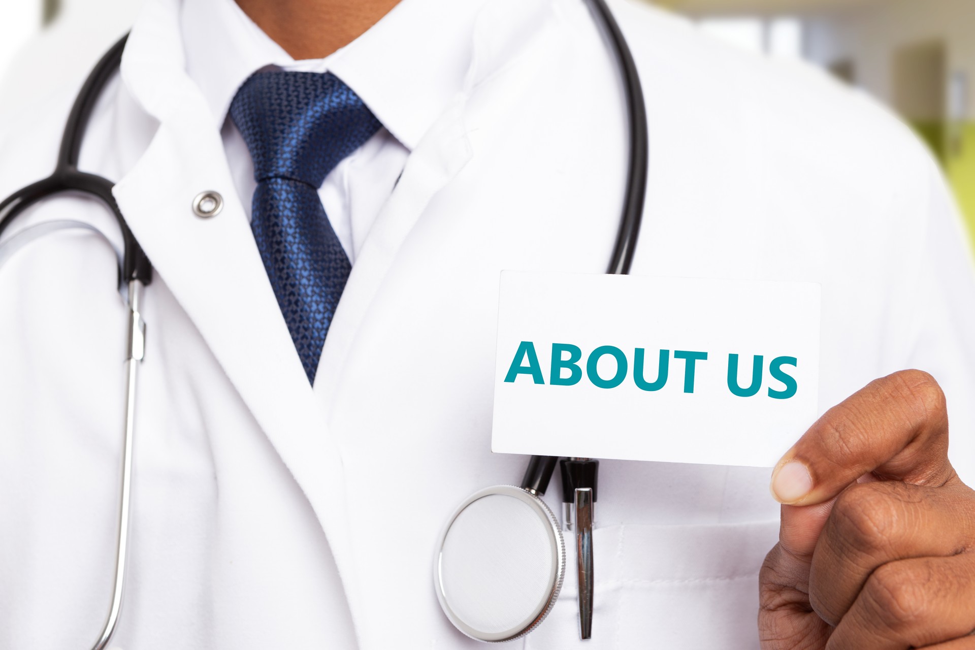 About us text on card held by physician About us text on card held by physician